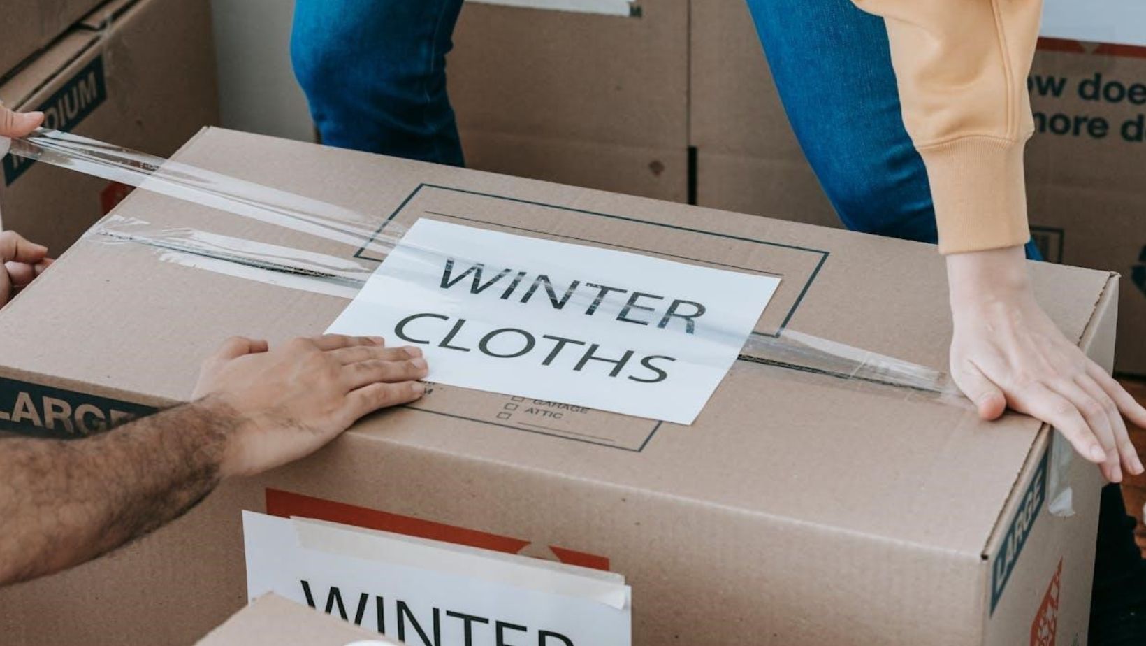 Couple closing a labeled box.