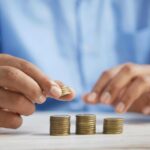 What Are The Benefits of Hiring Affordable Movers a person stacking coins on top of a table