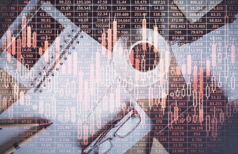 A work desk with a notebook, coffee cup, smartphone, and pen overlaid with transparent financial charts and numerical stock data, symbolizing market analysis and trading.