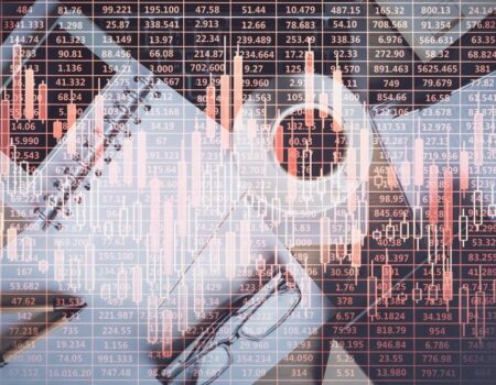 A work desk with a notebook, coffee cup, smartphone, and pen overlaid with transparent financial charts and numerical stock data, symbolizing market analysis and trading.